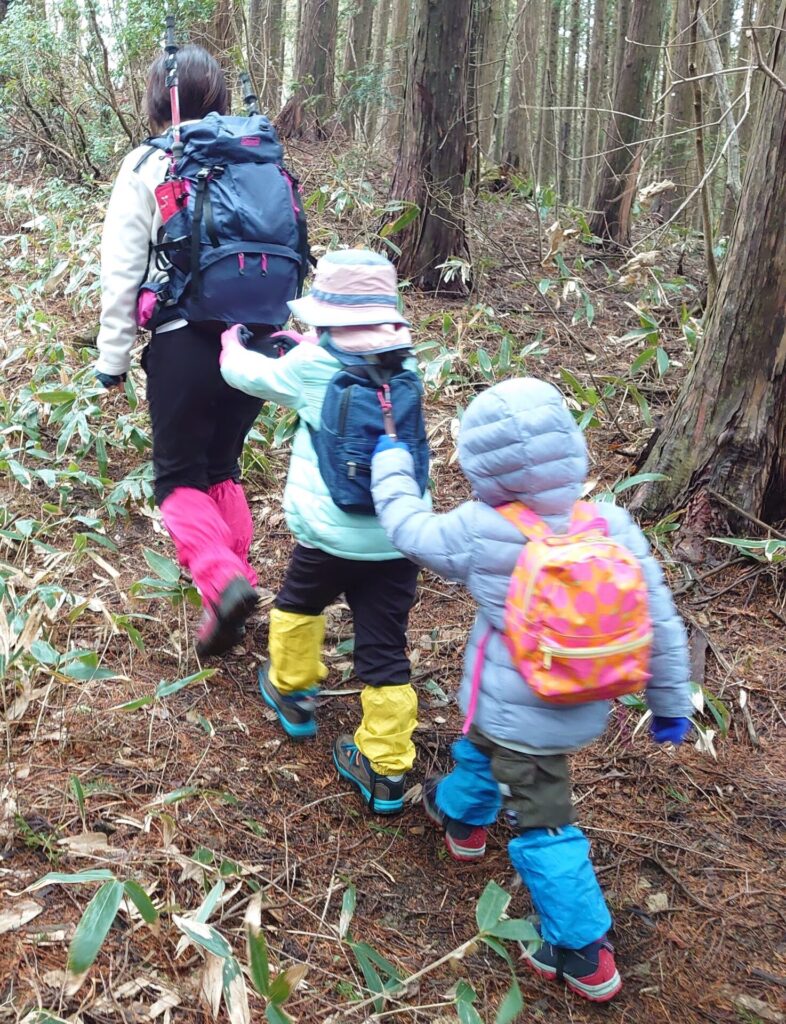 ママと小学低学年・保育園児の子ども3人がゲーターを履いて歩いている様子