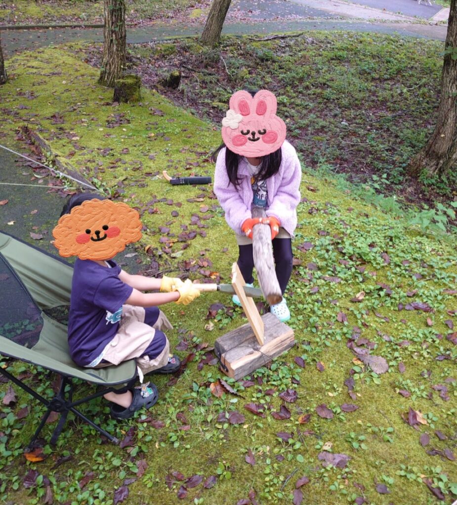 キャンプ場で親子いっしょに薪割りをする様子