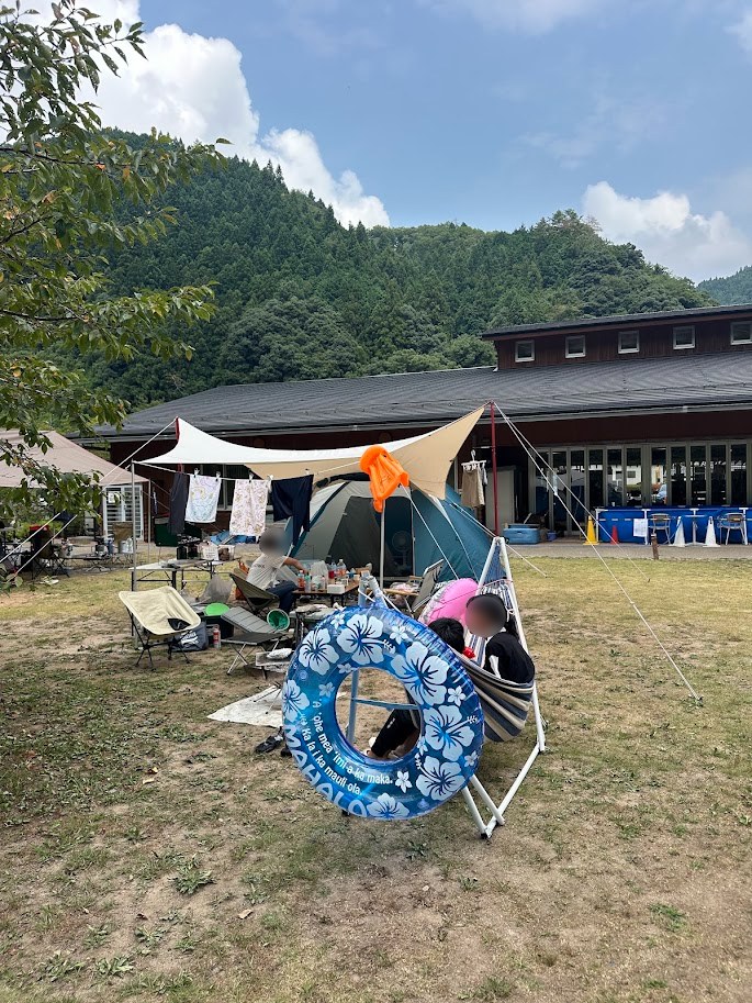 山を背にした湯来リバーサイドキャンプ場の区画サイト全景