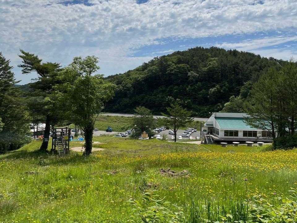 ゲレンデから振り返って見下ろした登山者用の駐車場と、右奥に建つスキー場のレストハウス