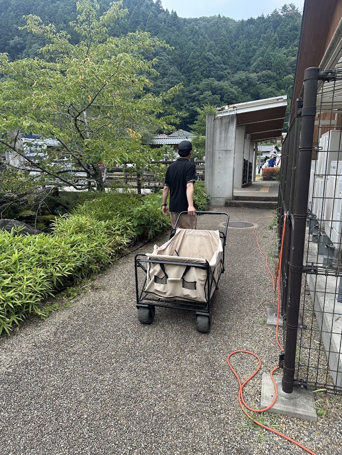 受付で貸し出されたリヤカーで駐車場からサイトへ荷物を運ぶ様子