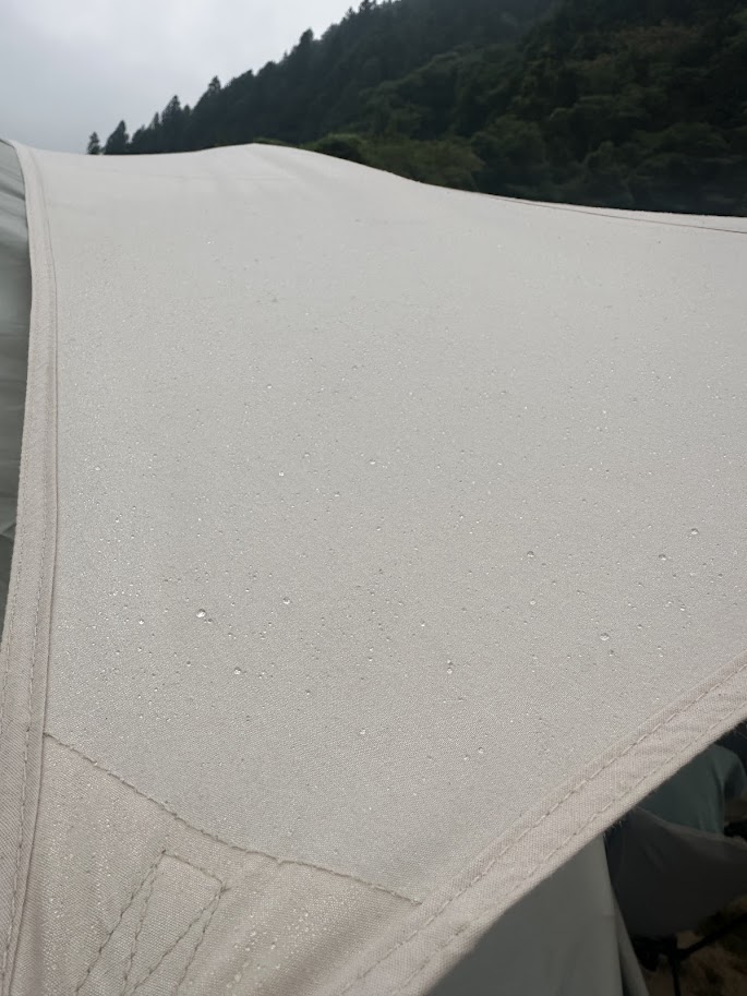 朝露で水滴だらけになったタープの表面