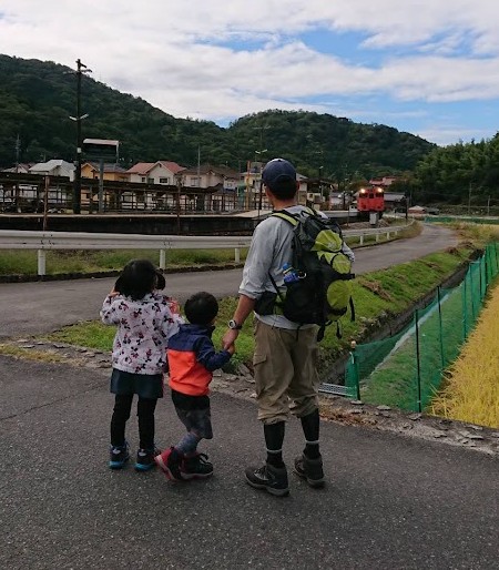 白木山駅の近くで電車を眺めるパパと子ども2人