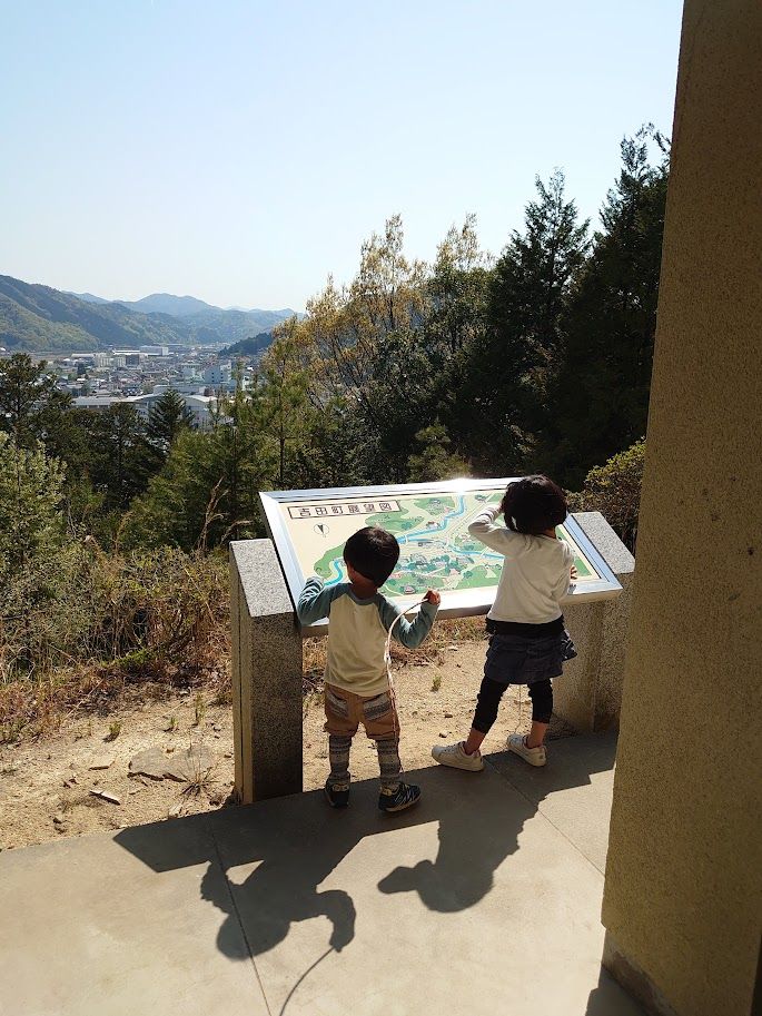 「吉田町鳥瞰図」の案内板を見ながら吉田の町を見下ろす子どもたち