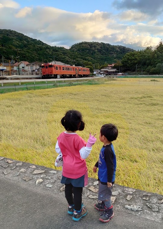 白木山駅近くの田んぼの横で電車を眺める娘と息子