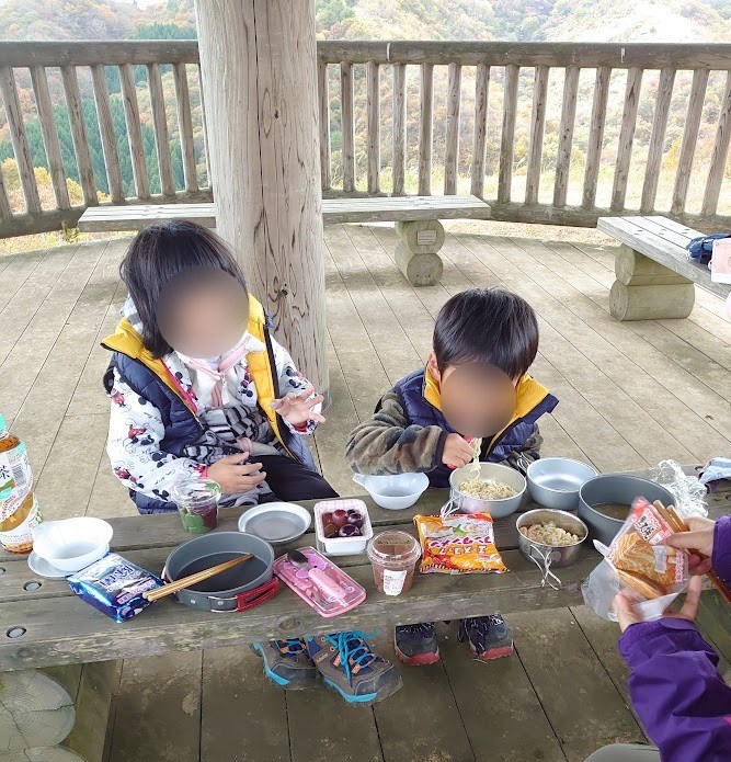 駐車場上の東屋でランチを食べる子どもたち