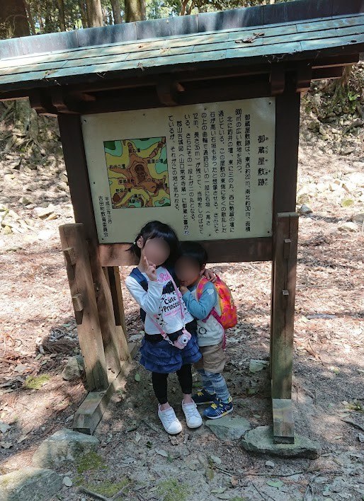 「御蔵屋敷跡」の説明板の前に並んでポーズをとる娘と息子