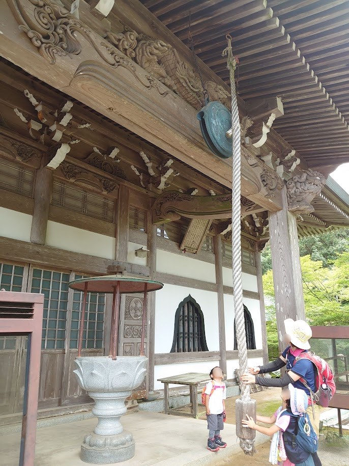 福王寺の本堂の前で鐘を鳴らす子どもたち