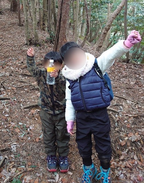 お湯を入れたペットボトルを持つ息子と、フリースにダウンベストを重ねた娘