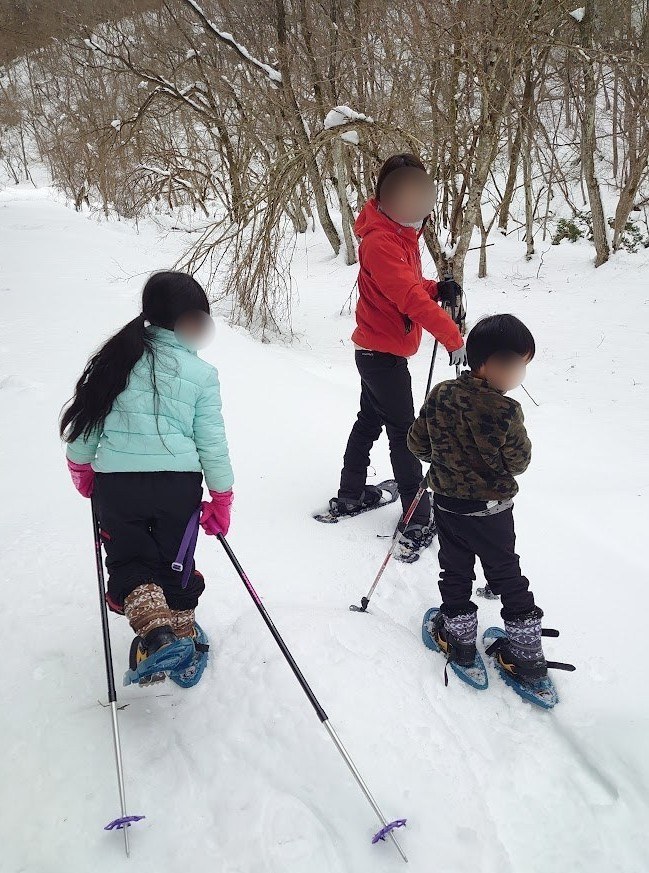 スノーシューで雪の中を歩く子どもたち